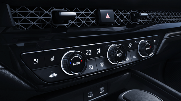 Gros plan de trois quarts des commandes de climatisation sur la console centrale.