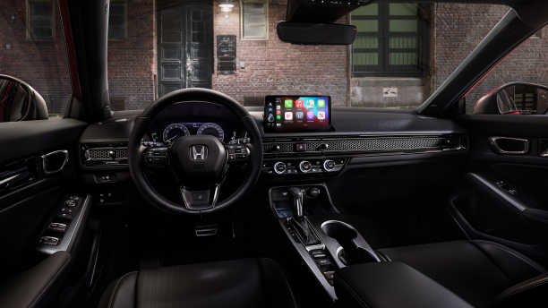 Interior panoramic view of the steering wheel and dashboard on a Hatchback parked in front of brick wall in an old warehouse district.