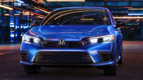 Avant d’une Civic berline bleue stationnée dans un espace sombre comme un entrepôt.