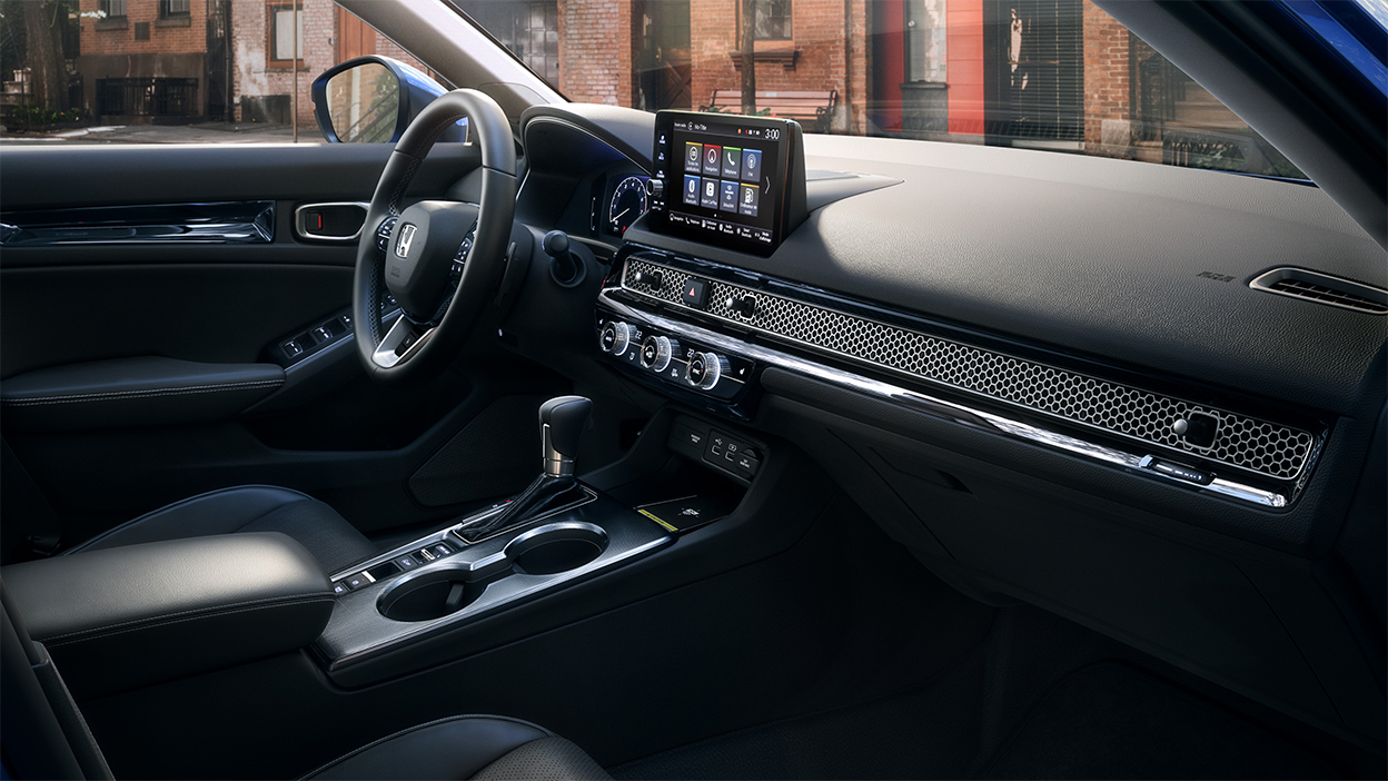 Plan latéral de la rangée avant, du côté passager, montrant le tableau de bord, la console centrale et le volant.