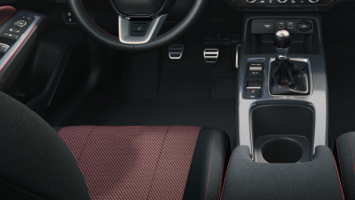 Siège du conducteur, pédales et console du levier de vitesses, vus depuis les sièges arrière.