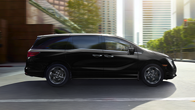 Sideview of black Odyssey on city street.