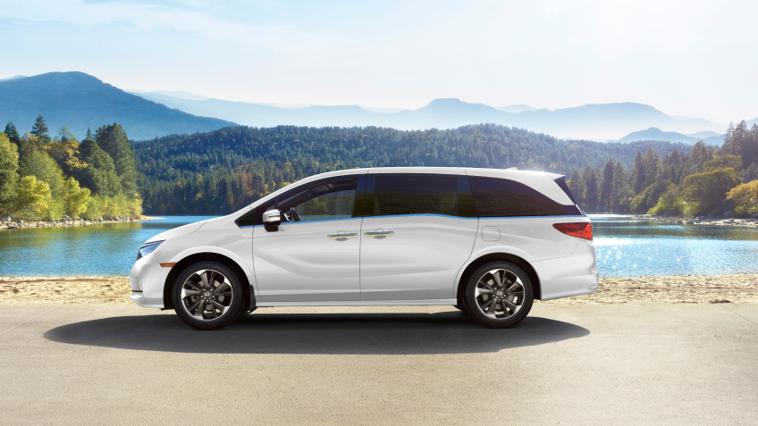 Sideview of white Odyssey, parked lakeside.