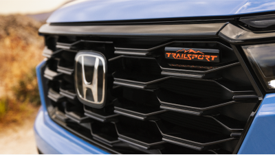 Closeup of front of light blue Pilot, showcasing its grille and the “TrailSport” emblem.