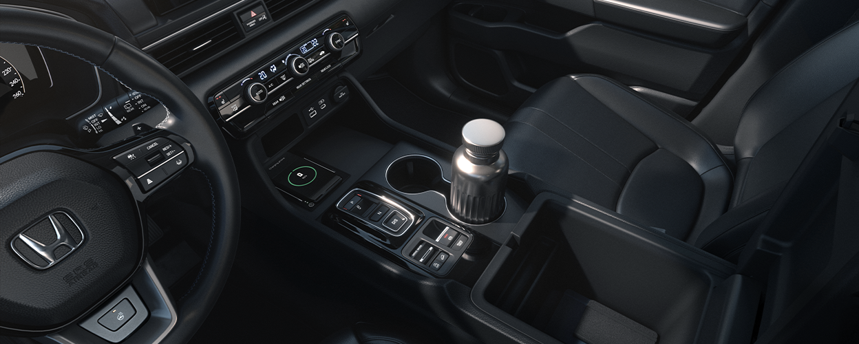 3/4 interior bird’s eye view showcasing the front row and centre console, with a water bottle in the cupholder.