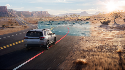 3/4 rear view of grey Pilot taking a curve on a desert highway. Blue sensor waves and lines emit from the front, detecting the white lane line.