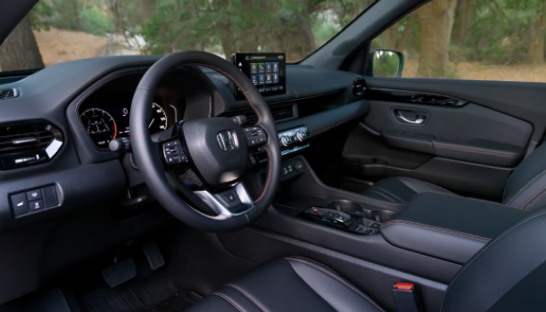 Driver’s side view of steering wheel, front seats, and front dashboard.