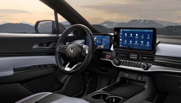 Plan large intérieur de trois quarts du tableau de bord et de la nouvelle console centrale. À travers le pare-brise, nous voyons des montagnes enneigées.