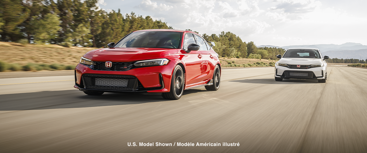 3/4 front view of a red Type R and a white Type R racing toward camera in a closed track circuit.